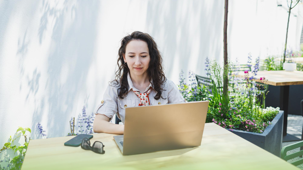 Agente de seguros trabajando desde su jardín en laptop gestionando clientes, pagos y vencimientos con CRM